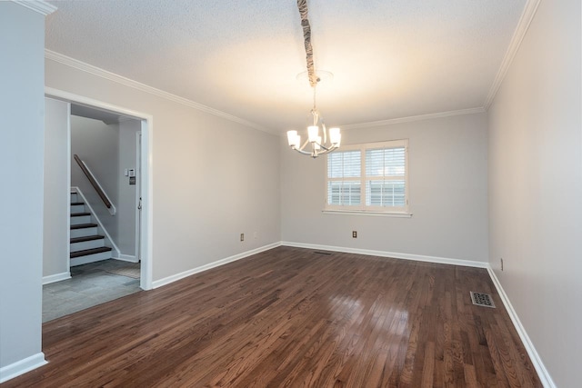 spare room with a chandelier, ornamental molding, a textured ceiling, and dark wood-type flooring