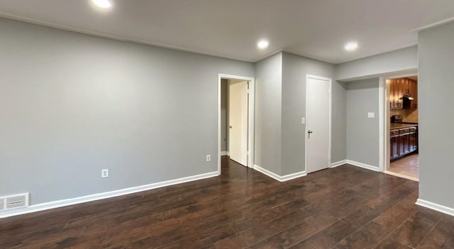 unfurnished room featuring baseboards, visible vents, dark wood-style flooring, and recessed lighting