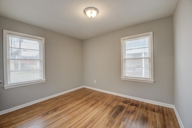 unfurnished room with baseboards and wood finished floors