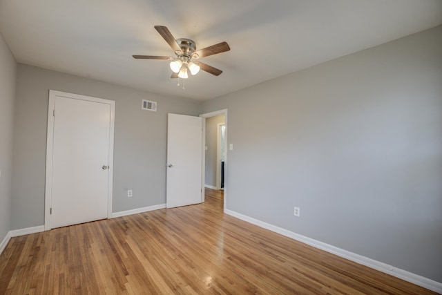 unfurnished bedroom with light wood finished floors, a ceiling fan, visible vents, and baseboards