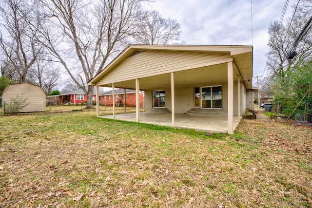 rear view of property featuring a yard, brick siding, a patio area, and fence