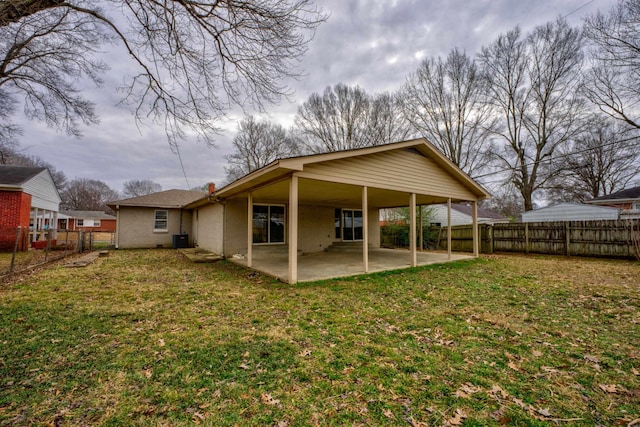 back of property with central air condition unit, a patio area, a fenced backyard, and a yard