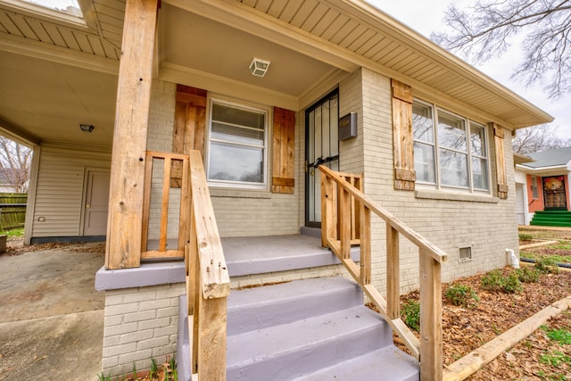 property entrance featuring crawl space, a porch, and brick siding