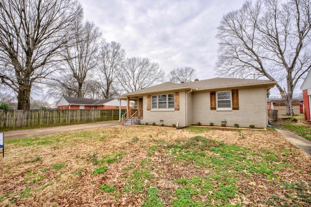 view of front of home with brick siding, crawl space, and fence