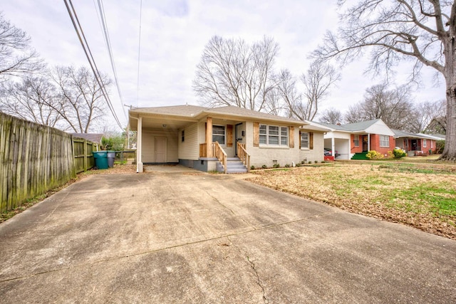 view of front facade with brick siding, concrete driveway, crawl space, fence, and an attached carport