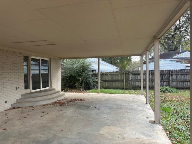 view of patio featuring entry steps, a carport, and fence