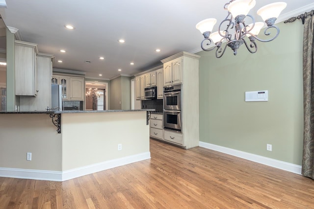 kitchen with stainless steel appliances, light hardwood / wood-style flooring, crown molding, and tasteful backsplash