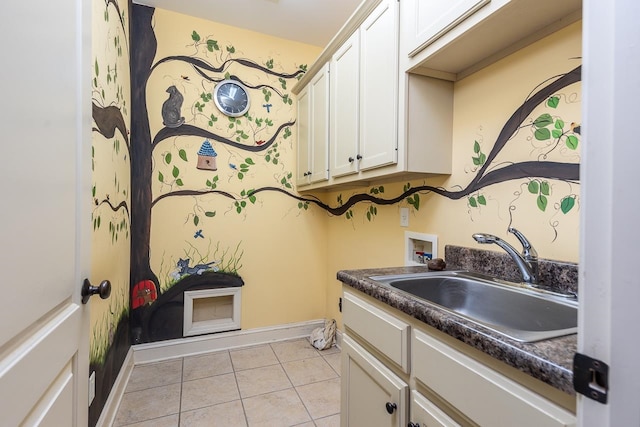 laundry room with cabinets, hookup for a washing machine, light tile patterned floors, and sink