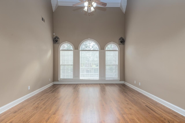 empty room featuring high vaulted ceiling, light wood-type flooring, and ceiling fan