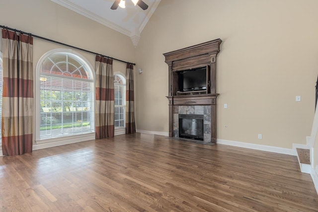 unfurnished living room with ceiling fan, hardwood / wood-style flooring, high vaulted ceiling, and crown molding