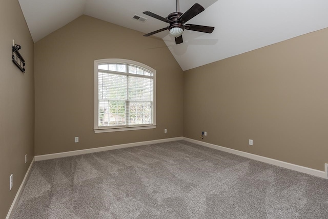 empty room featuring lofted ceiling, light colored carpet, and ceiling fan