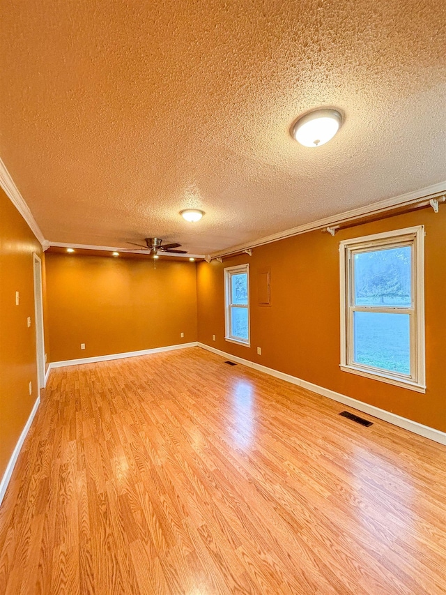 spare room with hardwood / wood-style flooring, a textured ceiling, crown molding, and ceiling fan