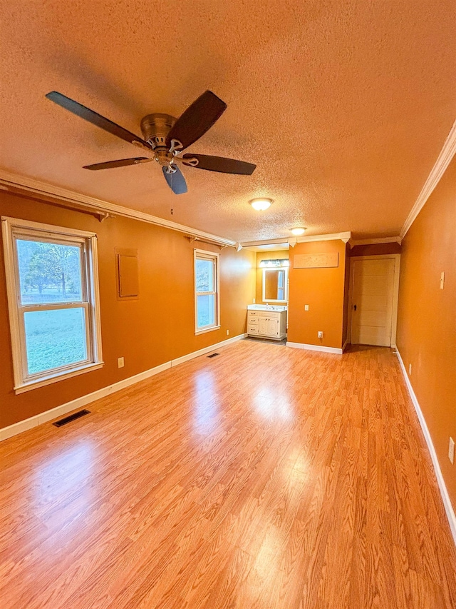 unfurnished living room featuring light hardwood / wood-style floors, ceiling fan, a textured ceiling, and ornamental molding