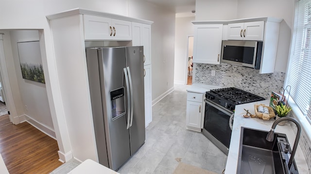 kitchen with white cabinetry, a wealth of natural light, decorative backsplash, and stainless steel appliances