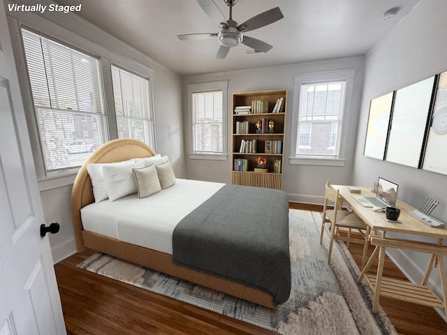 bedroom with dark wood-type flooring, ceiling fan, and multiple windows