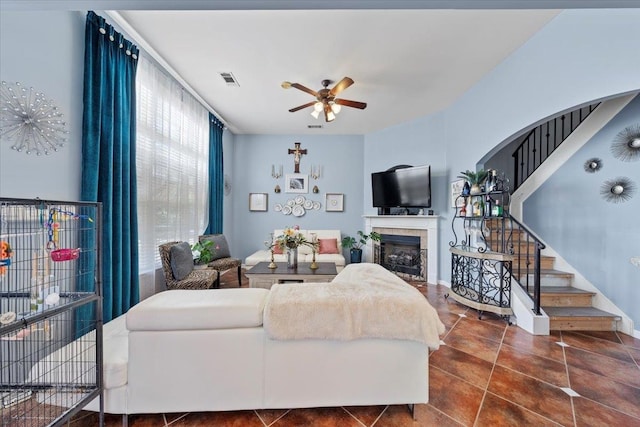 living room with a fireplace and ceiling fan