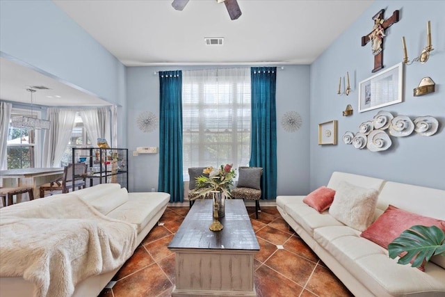 living room with ceiling fan and dark tile patterned floors