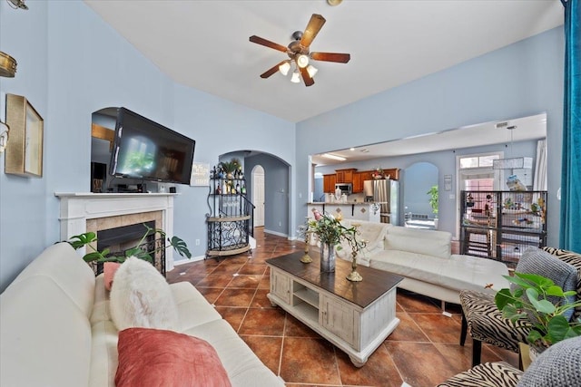 tiled living room featuring a tile fireplace and ceiling fan