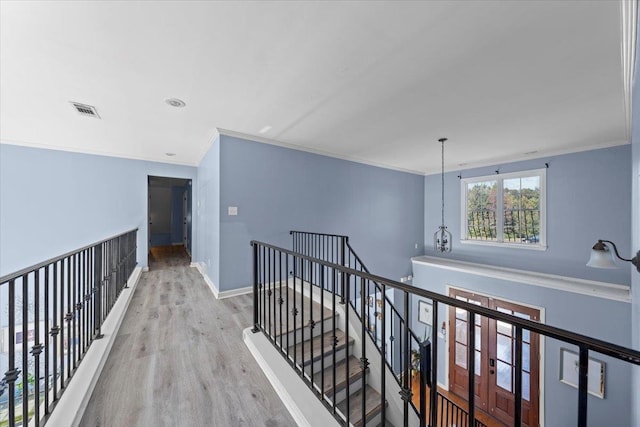 corridor featuring ornamental molding and light hardwood / wood-style floors