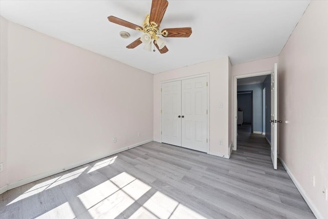 unfurnished bedroom with light hardwood / wood-style floors, ceiling fan, and a closet