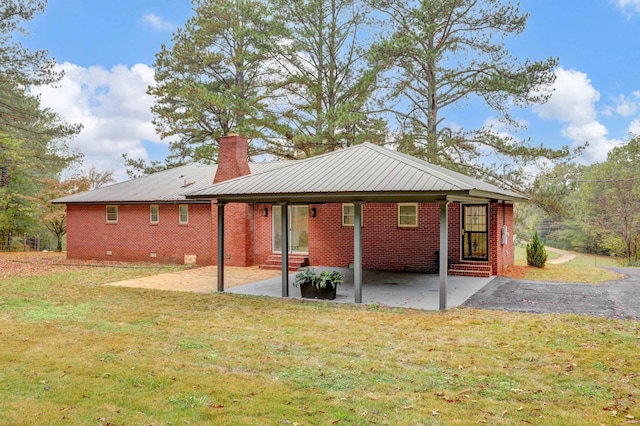 back of house with a lawn and a patio