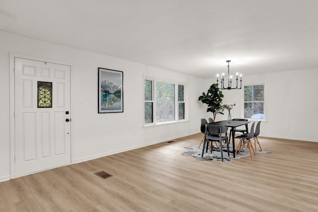 dining area featuring light hardwood / wood-style flooring and an inviting chandelier