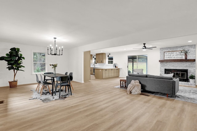 dining space featuring a fireplace, light hardwood / wood-style floors, and plenty of natural light