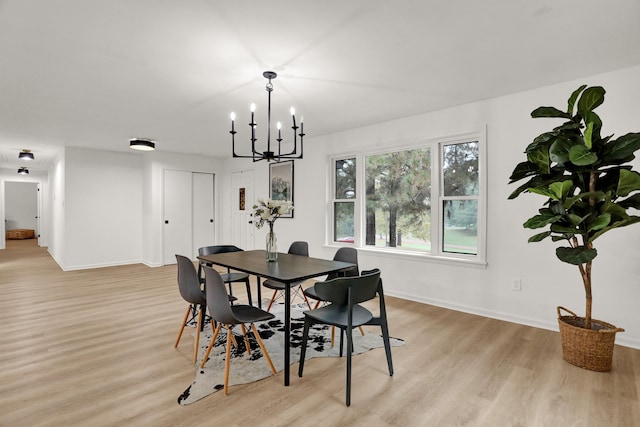 dining area with a chandelier and light hardwood / wood-style flooring