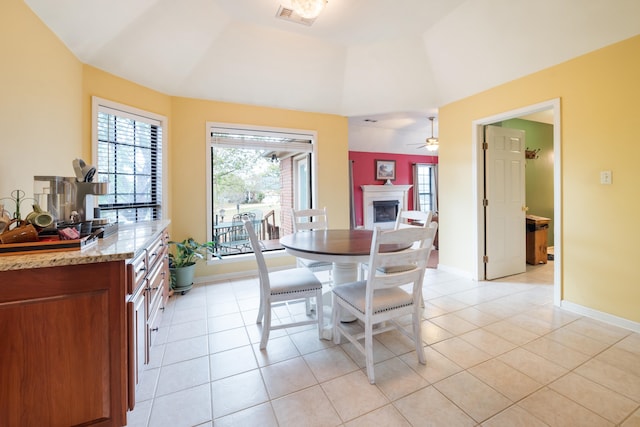 tiled dining room with ceiling fan and lofted ceiling