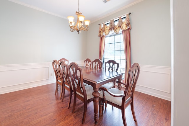 dining area featuring an inviting chandelier, dark hardwood / wood-style floors, and ornamental molding