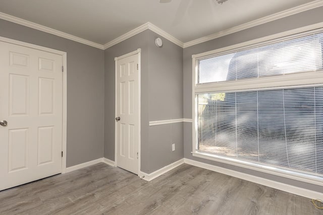 unfurnished bedroom featuring crown molding and light hardwood / wood-style floors