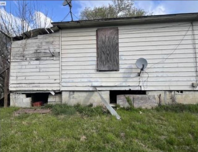 view of side of home with a lawn