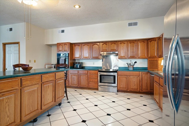 kitchen featuring a textured ceiling and stainless steel appliances