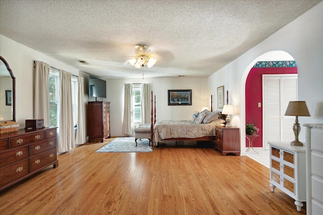 bedroom featuring a textured ceiling, light hardwood / wood-style flooring, and ceiling fan