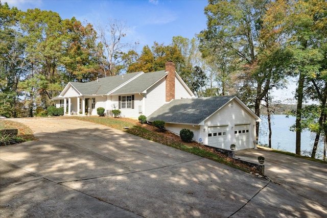 exterior space featuring a garage, a water view, and covered porch