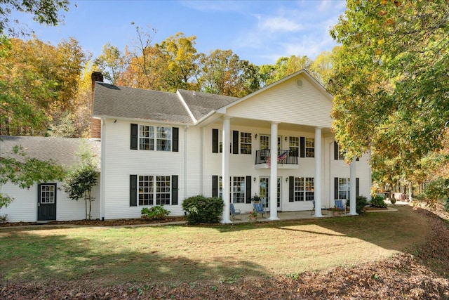 view of front of home featuring a front lawn and a balcony