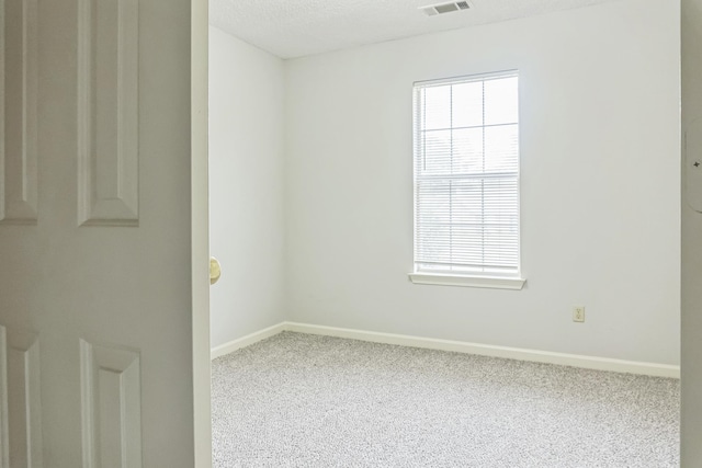 carpeted spare room featuring a textured ceiling