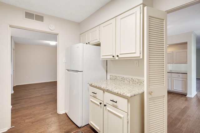 kitchen featuring white cabinetry, white fridge, and dark hardwood / wood-style flooring