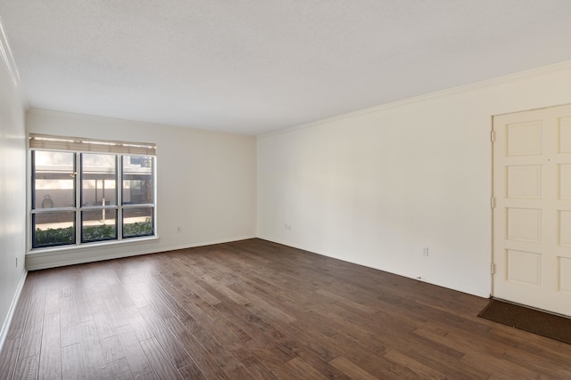 spare room with dark wood-type flooring, a textured ceiling, and ornamental molding