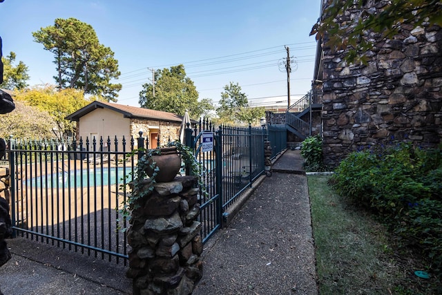 view of gate featuring a storage unit and a community pool