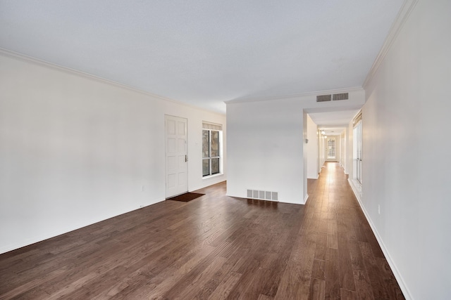 empty room featuring dark hardwood / wood-style floors and ornamental molding