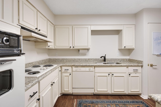 kitchen with sink, light stone counters, white appliances, white cabinets, and dark wood-type flooring