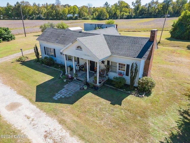 view of front of property with a patio, a rural view, and a front lawn