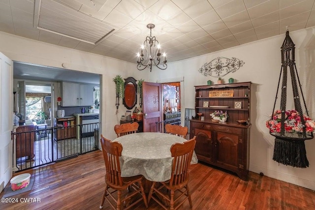 dining area featuring dark wood-type flooring, a notable chandelier, and ornamental molding