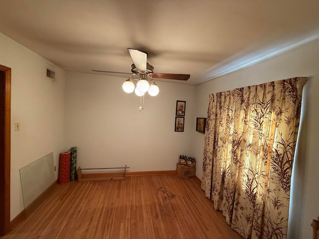 empty room with light wood-type flooring and ceiling fan