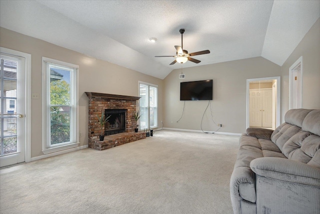 carpeted living room with a textured ceiling, vaulted ceiling, ceiling fan, and a brick fireplace