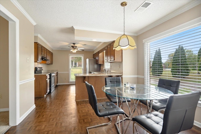 dining area with ceiling fan, dark parquet flooring, a textured ceiling, and ornamental molding