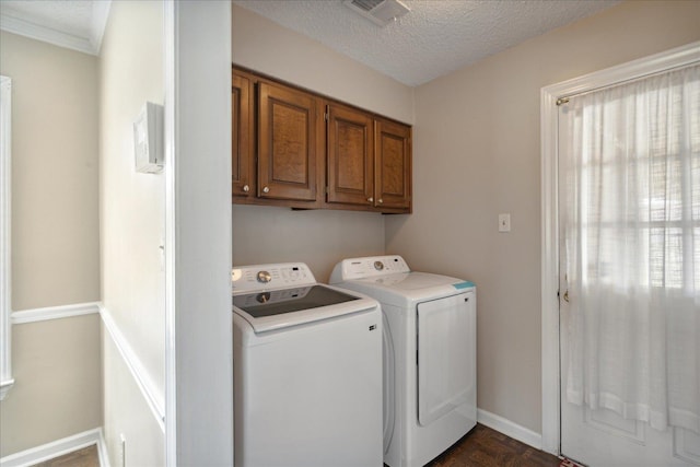 laundry area featuring cabinets, dark parquet flooring, a textured ceiling, and washer and dryer