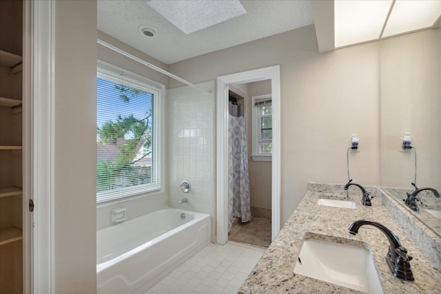 bathroom featuring vanity, a textured ceiling, tile patterned floors, and a skylight