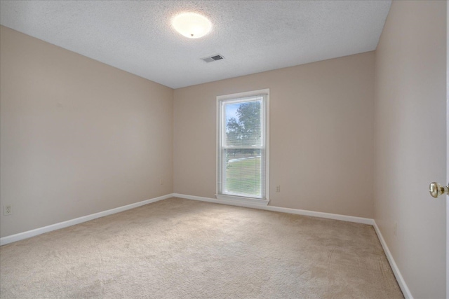 carpeted empty room with a textured ceiling